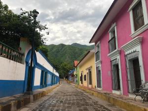 a cobblestone street in a town with colorful buildings at Copper Canyon Riverside Lodge in Batopilas