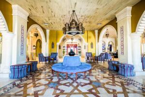 een grote kamer met blauwe stoelen en een tafel bij Sunrise Mamlouk Palace Resort in Hurghada