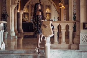 Sunrise Mamlouk Palace Resort في الغردقة: امرأة تقف في مدخل عقد حقيبة