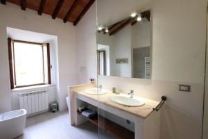 a bathroom with two sinks and a mirror at La Casa nel Borgo in Monticchiello +41 photos