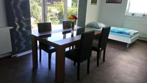 a dining room with a table and chairs and a bed at Apartment Ahrbergen in Giesen
