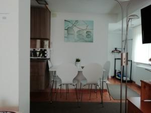 a dining room with white chairs and a table at Apartment Beganovic in Kulen Vakuf