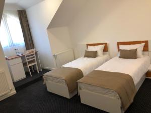 a hotel room with two beds and a table at Pensiunea Piscul Cainelui in Sinaia