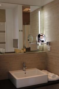 een badkamer met een wastafel en een spiegel bij Heiner's Parkhotel in Gelsenkirchen