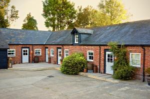 ein rotes Backsteingebäude mit weißen Türen und Fenstern in der Unterkunft Hazelhurst Farm in Sway