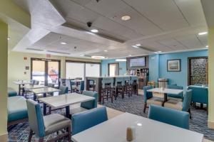 a dining room with tables and blue chairs at La Quinta by Wyndham Sevierville / Kodak in Sevierville