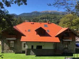 a house with an orange roof on top of it at Pensiunea Piscul Cainelui in Sinaia