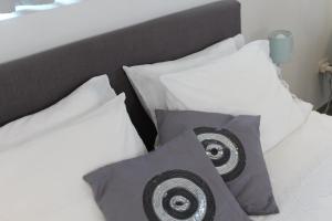 uma cama com almofadas brancas e uma cabeceira em preto e branco em Studio tout neuf. Court séjour, loisirs, professionnel em Chaudfontaine