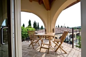 eine Terrasse mit einem Tisch und Stühlen auf dem Balkon in der Unterkunft Agriturismo Pratello in Padenghe sul Garda