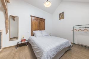 1 dormitorio con cama blanca y cabecero de madera en Le Clos Moussy en Moussy