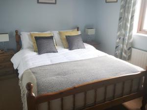 a bedroom with a bed with white sheets and pillows at CF10 House - Cardiff City Centre in Cardiff