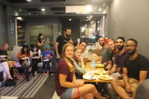 a group of people sitting around a table eating at Sleepy Raccoon Hostel in Jakarta