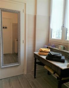 ein Bad mit einem Spiegel und einem Tisch mit Handtüchern in der Unterkunft Le Clos Sainte Foy in Morlaas