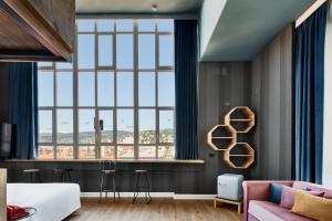 Habitación con ventana grande y sofá en The Modernist Hotel, en Trieste