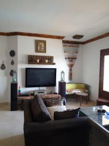 a living room with a couch and a flat screen tv at Dar Om Ali ElGouna Sabina y160 2 14 in El Gouna