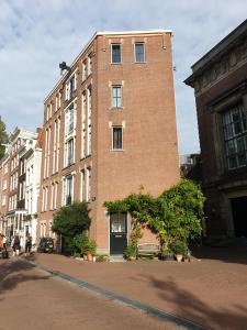 a tall brick building on the side of a street at Canal view suite in Amsterdam +7 photos