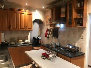 a kitchen with wooden cabinets and a white counter top at Turning Point Bed & Breakfast in Cape Town