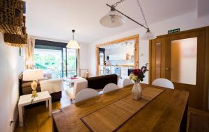 a dining room and living room with a table and chairs at Casarosaenea in Olite