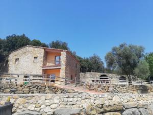 une ancienne maison en pierre avec un mur en pierre dans l'établissement Casa Rural Can Met, à Llorá