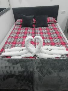 - 2 serviettes en forme de cœur sur un lit dans l'établissement Apartment Centar, à Užice