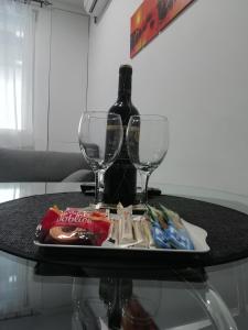 a table with two glasses and a bottle of wine at Apartment Centar in Užice