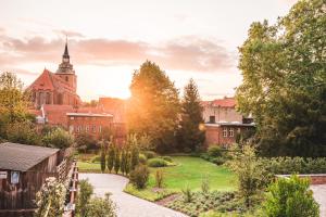 um jardim em frente a um edifício com uma igreja em Saltbloom Apartments em Lüneburg