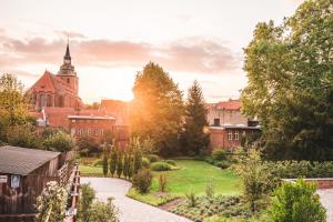 a garden in front of a building with a church at Saltbloom Apartments in Lüneburg