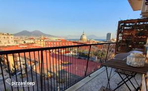 balcón con mesa y vistas a la ciudad en PizzaSleep B&B en Nápoles