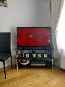 a television sitting on a table with a chair at 2 Bedrooms - 3 Beds - Free Parking - 168 in Stanwell