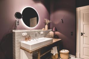 a bathroom with a white sink and a mirror at Saltbloom Apartments in Lüneburg +30 photos
