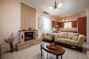 a living room with a couch and a fireplace at Villa Rosa 3 Bedroom with Sea View in Tragaki