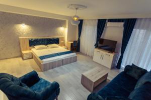 a bedroom with a bed and two couches at CITY HOTEL in Ferizaj