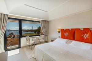 Hotel Cala Lunga في لا ماداّلينا: غرفة فندقية بسرير وطاولة وكراسي