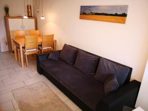 a living room with a black couch and a table at Wohnung "Flügge" in Bannesdorf
