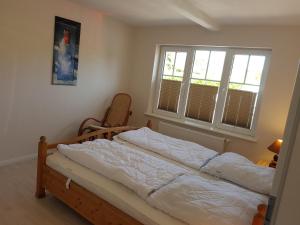 une chambre avec un lit et deux fenêtres dans l'établissement Wohnung "Flügge", à Bannesdorf