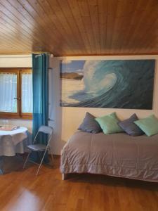 a bedroom with a bed and a painting on the wall at Maison du Fey in Moudon