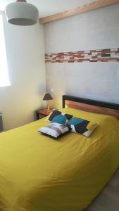 - une chambre avec un lit jaune et des oreillers dans l'établissement Appartement Cap Sud Vue Mer à 30m de la Plage, à Wimereux