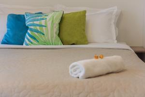 ein weißes Handtuch auf einem Bett mit Kissen in der Unterkunft Gold Class Apartment AMS 63 in Cluj-Napoca