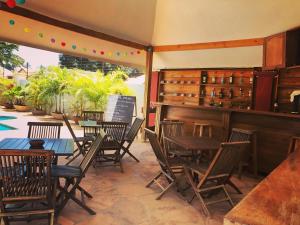 桑給巴爾的住宿－Green Turaco，一间带木桌和椅子的餐厅以及庭院