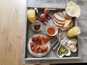 a tray of breakfast food with eggs and bread and orange juice at LA RIVIERE DU BIEN ETRE in Chaumont-Gistoux