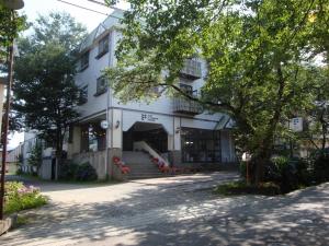 un gran edificio blanco con escaleras y un árbol en Hotel La Montagne Furuhata, en Hakuba