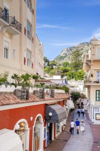 un grupo de personas caminando por una calle entre edificios en Camerelle 33 Capri, en Capri