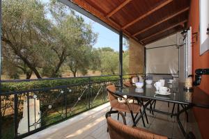 a table and chairs on a balcony with a view at VILLA ERMIONI in Melíkia