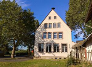 una casa bianca con un gambero di Alte Schule Gästehaus - The principal's rooms Appartment a Bitburg