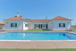 a large swimming pool in front of a house at Quinta da Pinheira Lezíria in Alpiarça