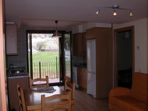a kitchen with a table and chairs and a kitchen with a window at Apartamento Millas in San Juan de Plan