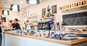 a woman standing at the counter of a coffee shop at Il Cortile in Bra