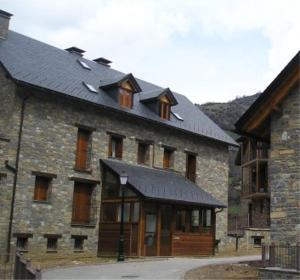 a large stone building with a black roof at Apartamento Millas in San Juan de Plan