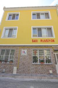 エディルネにあるSari Pensionの塩許可の看板を付けた黄色い建物