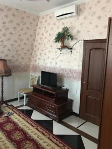 a room with a wooden dresser with a television on it at Отель Буржуа in Zhytomyr